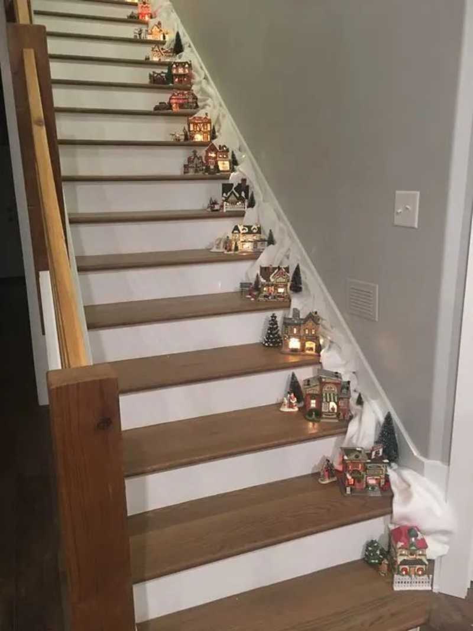 Escalera interior decorada con casitas decorativas de Navidad.