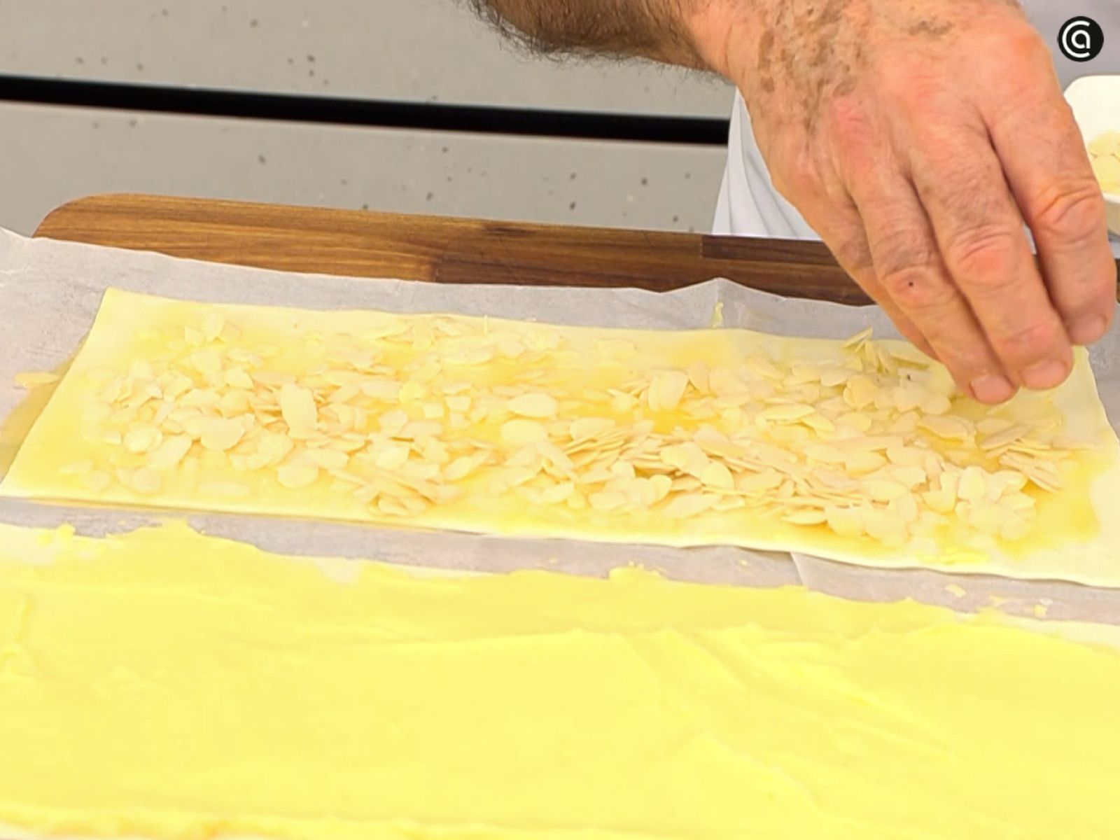 Las almendras laminadas se distribuyen sobre la superficie pincelada para que queden bien repartidas.