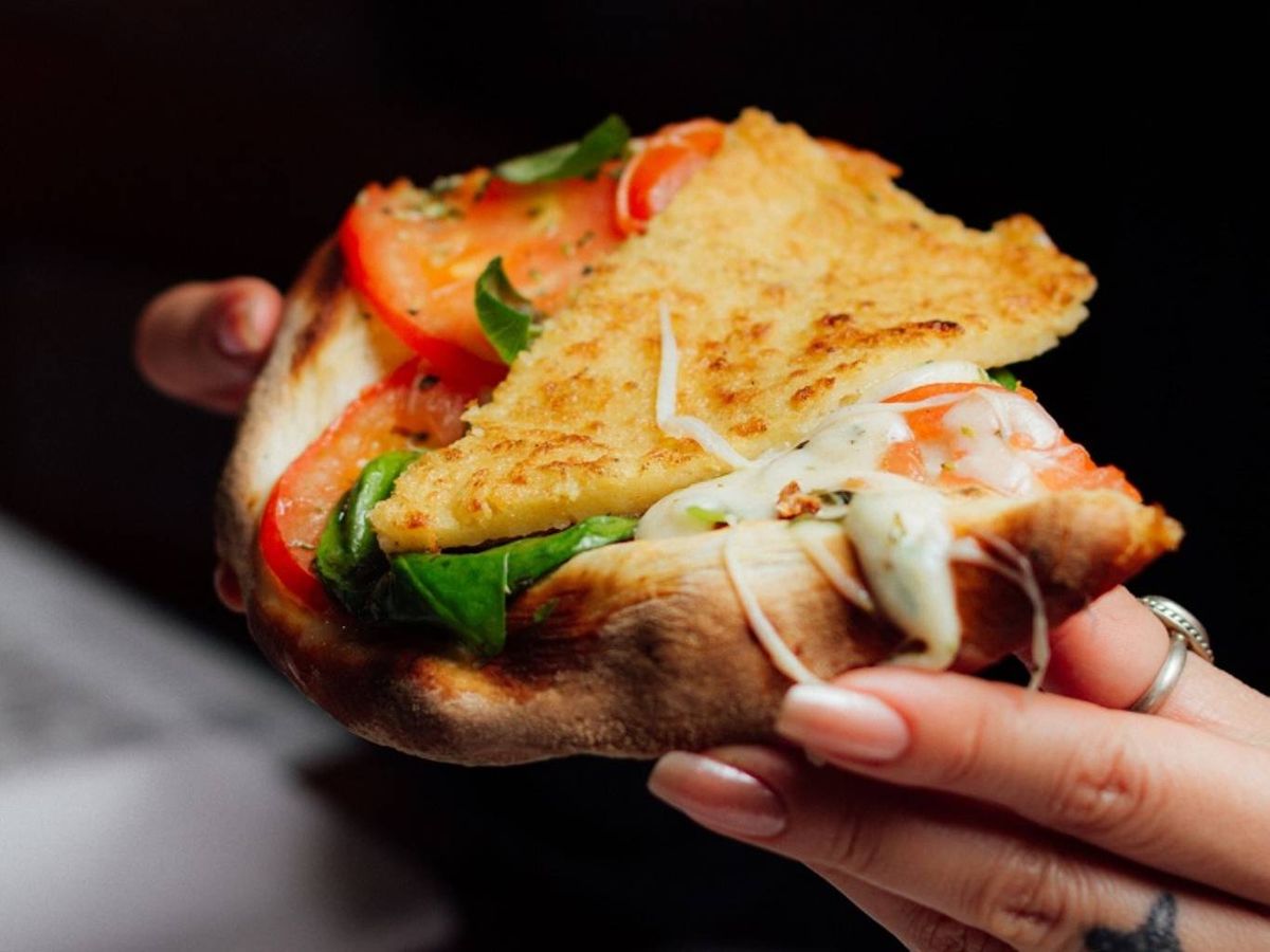 La pizza argentina se acompaña tradicionalmente con fainá, una torta de garbanzo