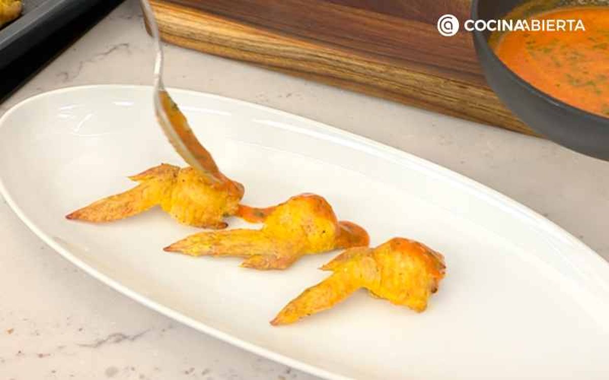 Sirve las alitas de pollo rellenas con salsa picante