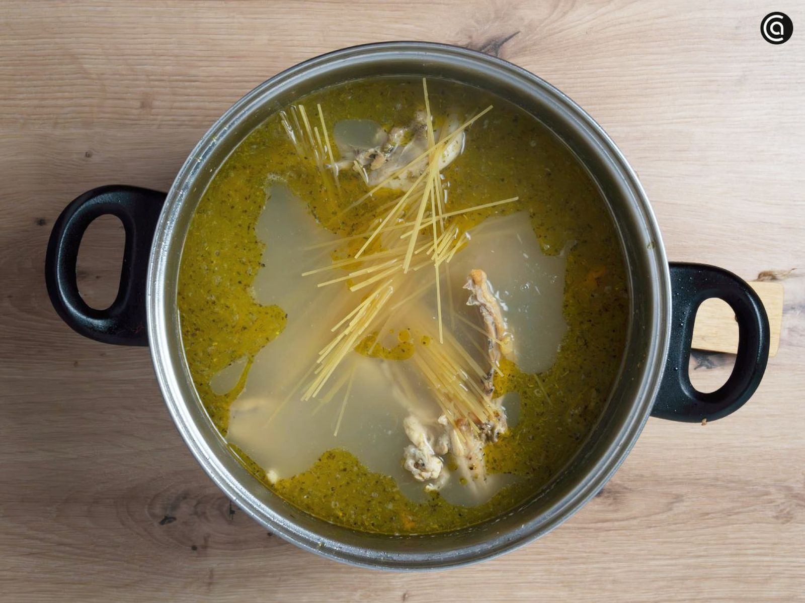 Echa los espaguetis finos en el caldo de pollo casero y remueve