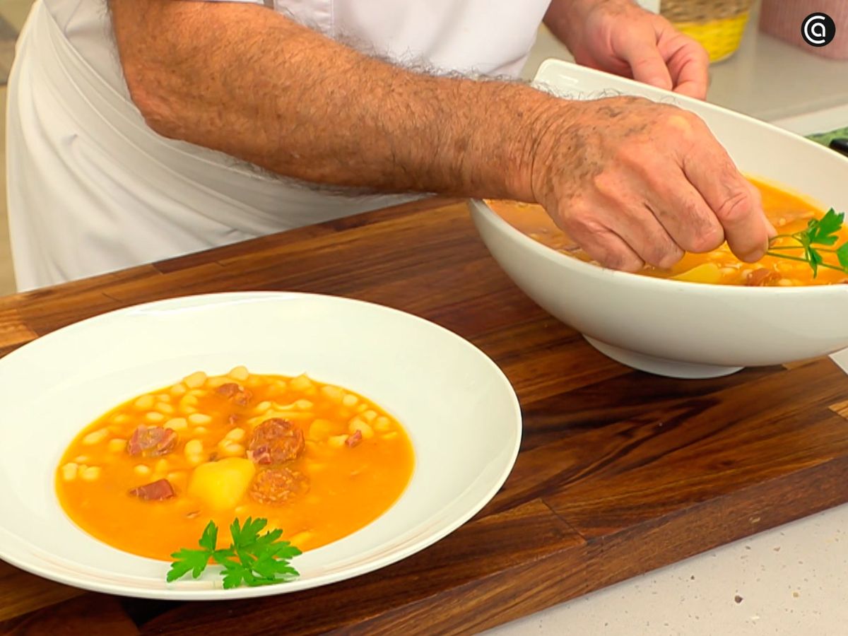 Decora con una hoja de perejil las alubias blancas con chorizo