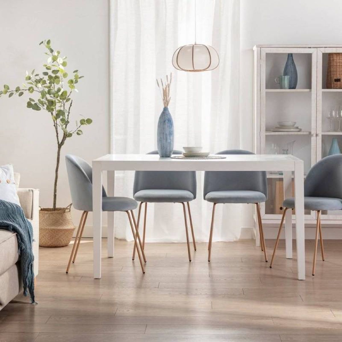 Comedor elegante en azul con mesa rectangular blanca.