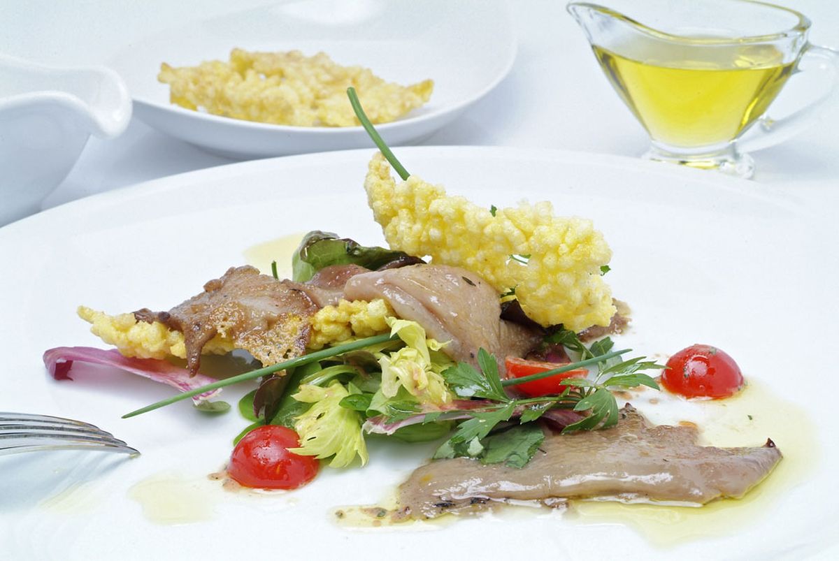 Crestas de gallo fritas con ensalada y crujiente de arroz