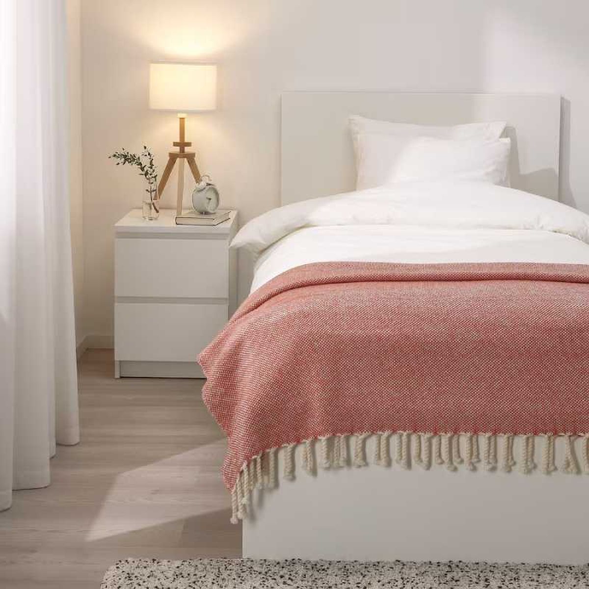 Dormitorio acogedor con manta a los pies de la cama.