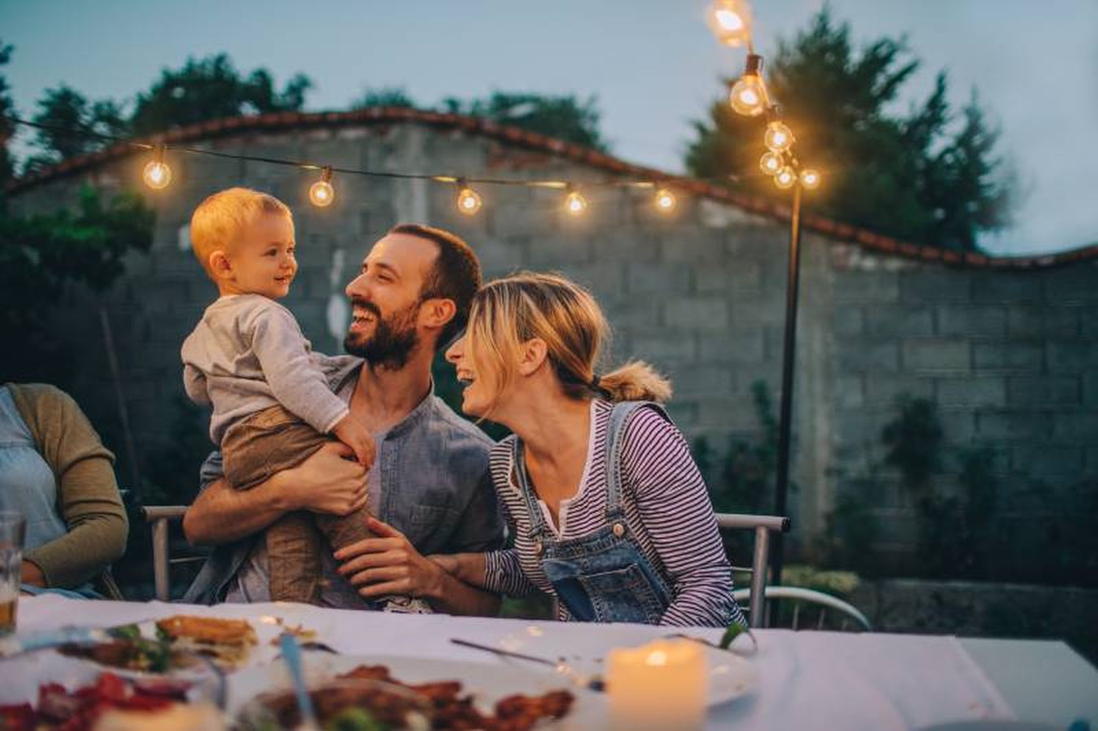 Pareja con un bebé en una cena familiar en el exterior. Pareja con un bebé en una cena familiar en el exterior.