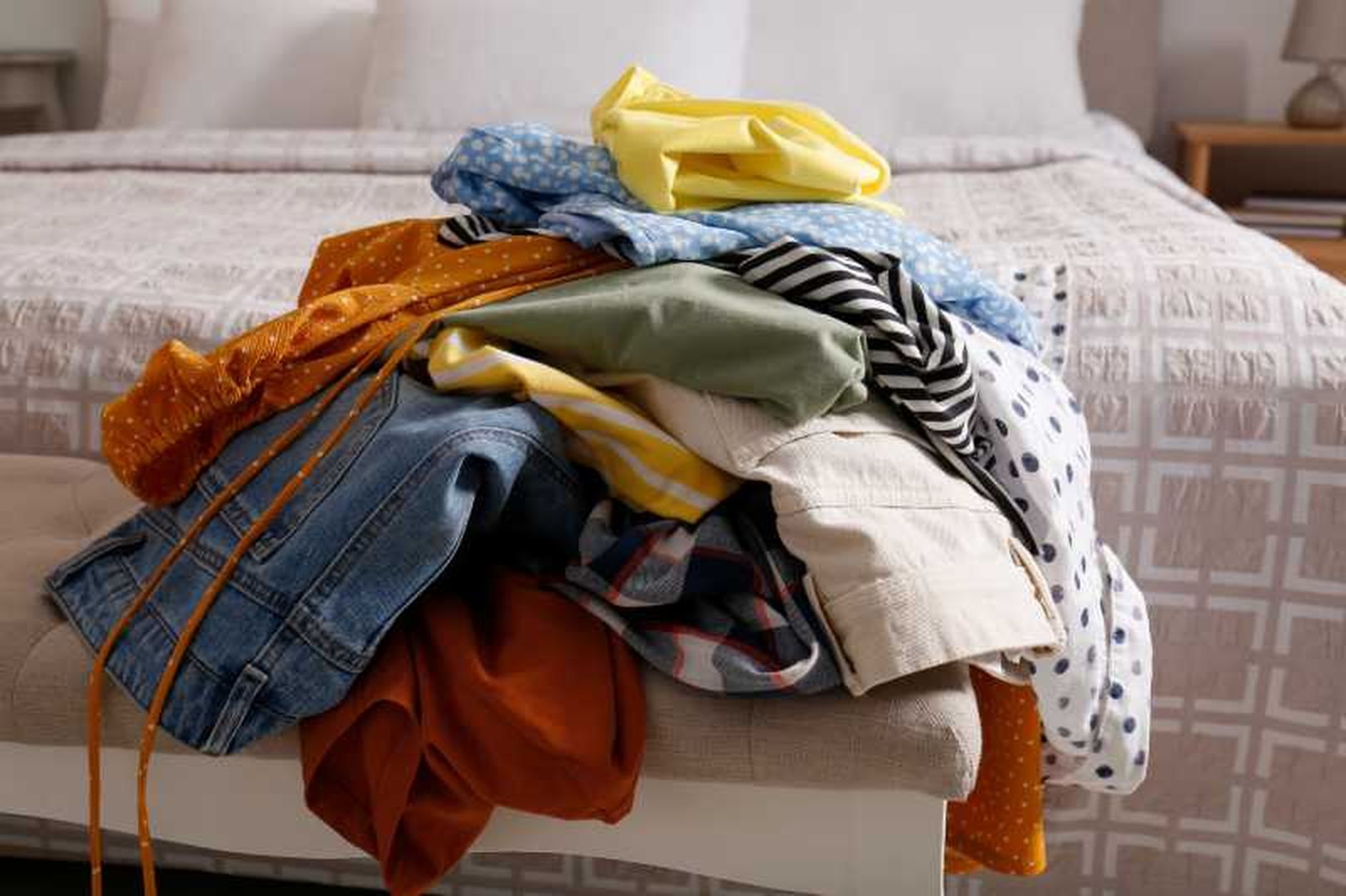 Montaña de ropa desordenada sobre la cama. Montaña de ropa desordenada sobre la cama.