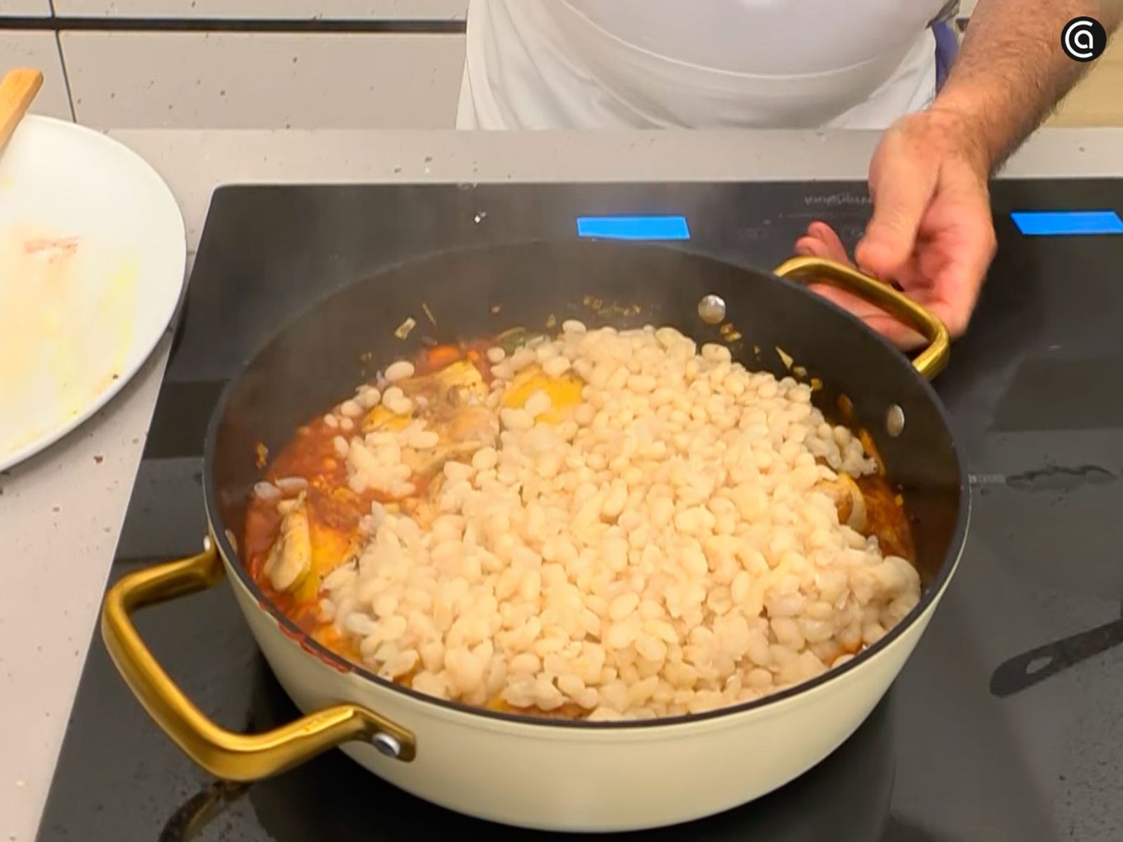 Vierte el caldo de la cocción, incorpora las alubias y el pollo, y cocina Vierte el caldo de la cocción, incorpora las alubias y el pollo, y cocina