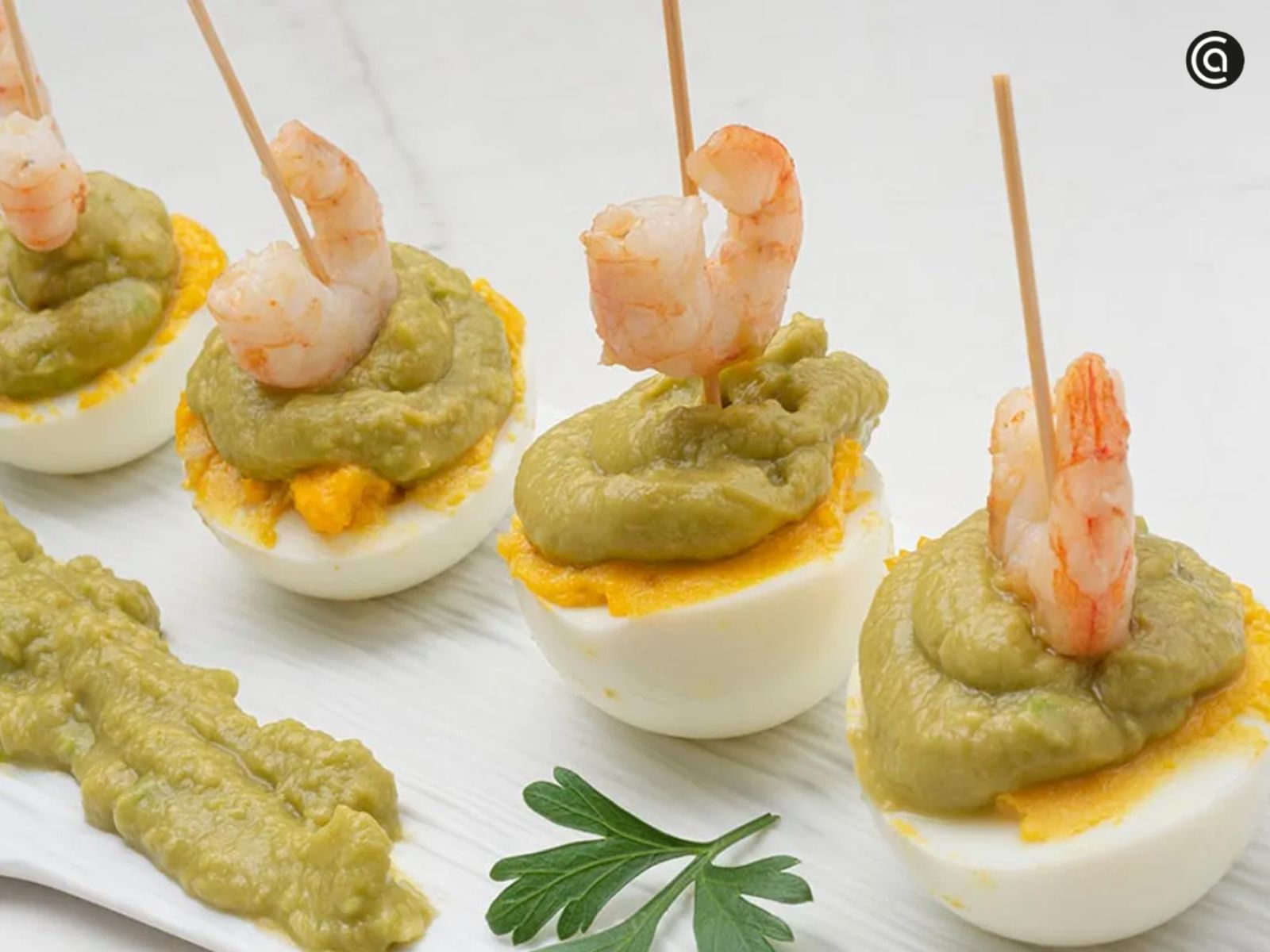Un aperitivo distinto: huevos rellenos de guacamole con gambas. Un aperitivo distinto: huevos rellenos de guacamole con gambas.