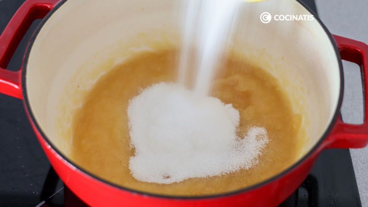 Agregar azúcar a las manzanas en la cazuela