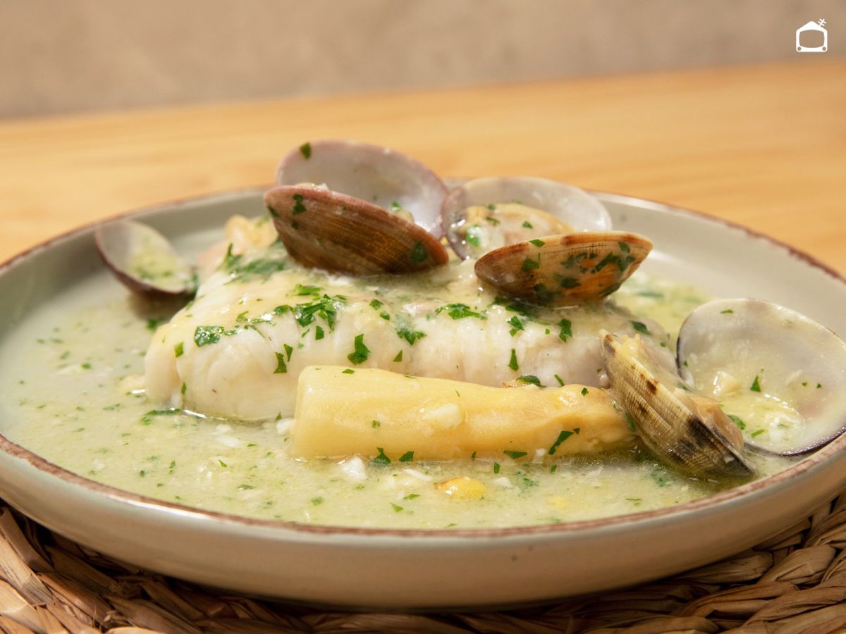 Acompaña la merluza con las almejas y los espárragos, y napa con la salsa verde