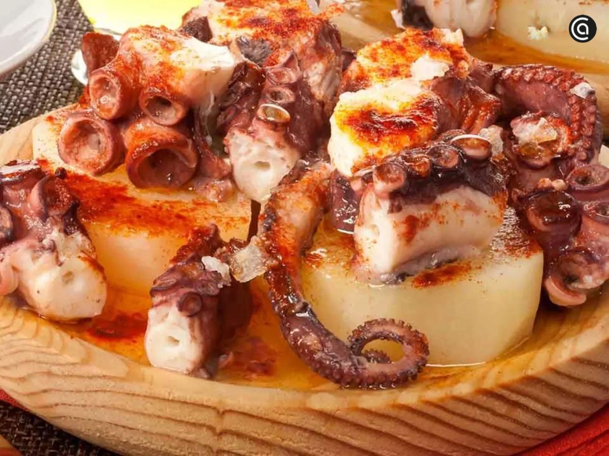 Pulpo a la gallega tradicional: servido sobre cachelos con sal gruesa, pimentón y aceite.