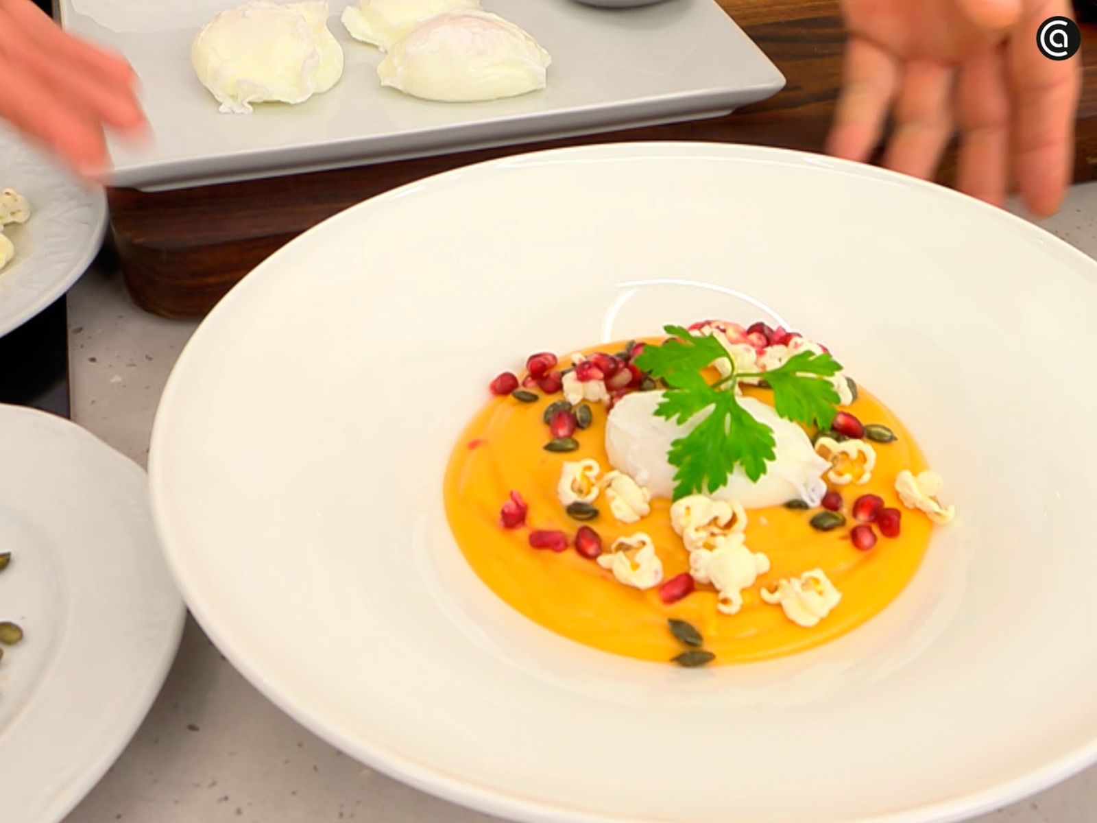 Sirve la crema de boniato y añade por encima el huevo poché, los granos de granada y unas palomitas