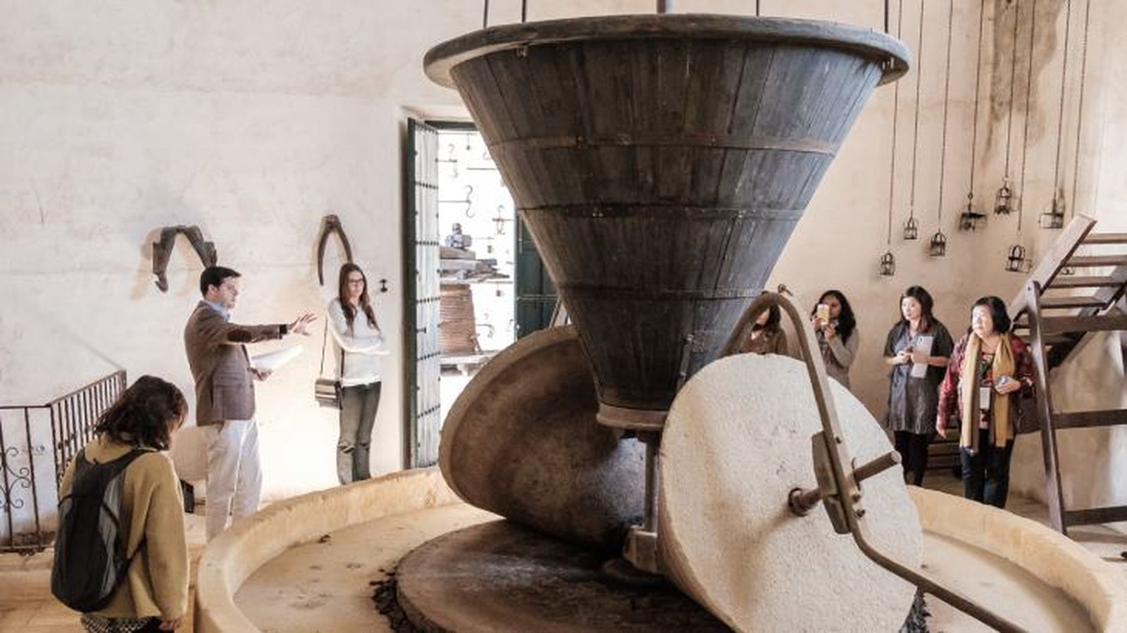 Un guía muestra el molino del siglo XVII a un grupo de oleoturistas Un guía muestra el molino del siglo XVII a un grupo de oleoturistas