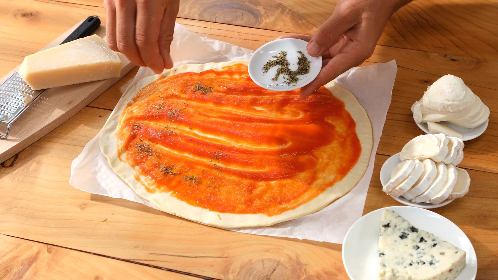Cubre la masa con salsa de tomate y espolvorea el orégano Pizza cuatro quesos Paso 1