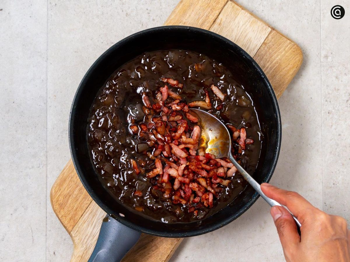 Añade el bacon a la cebolla caramelizada y mezcla bien