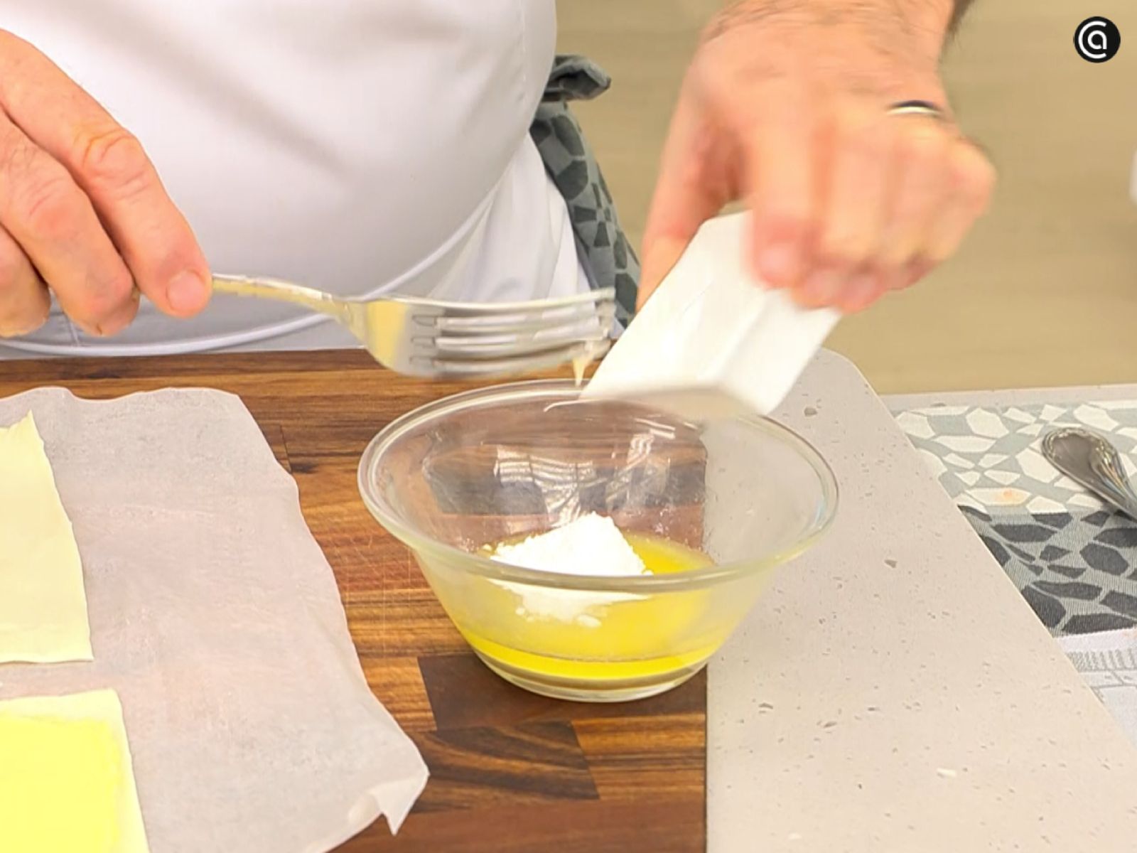 La mantequilla fundida, el azúcar glas y la miel se mezclan en un cuenco para pincelar la otra mitad del hojaldre.