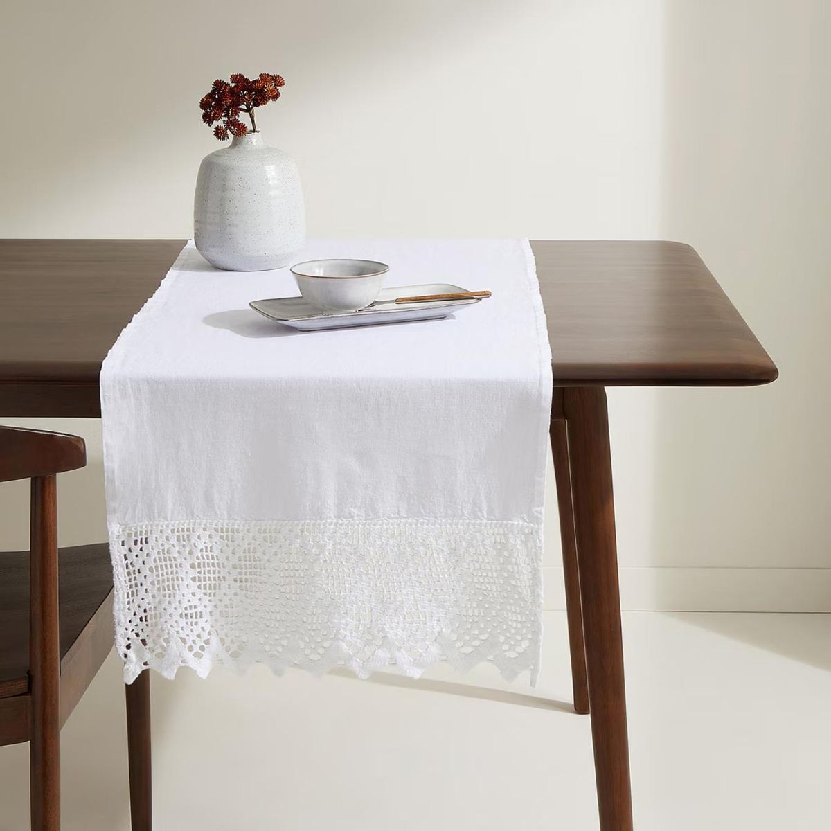 Camino de mesa elegante de lino y crochet.