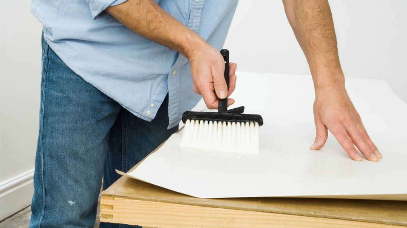 Aplicar cola en la parte trasera del papel de pintar Aplicar cola en la parte trasera del papel de pintar
