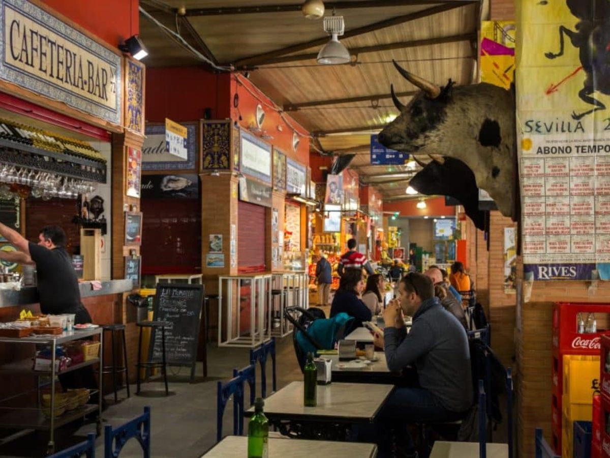 Ambiente en el Mercado de Triana, con bares y puestos de tapas donde saborear lo mejor de la gastronomía andaluza.