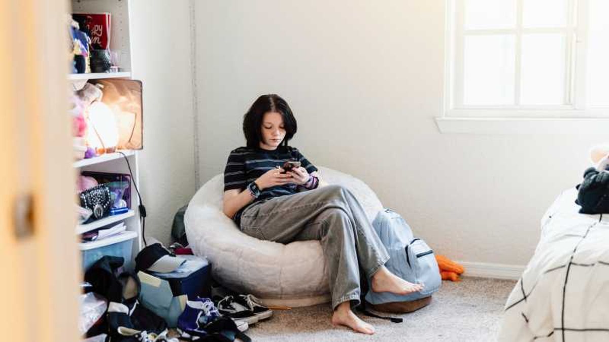 Adolescente con el dormitorio desordenado con mucho ruido visual.