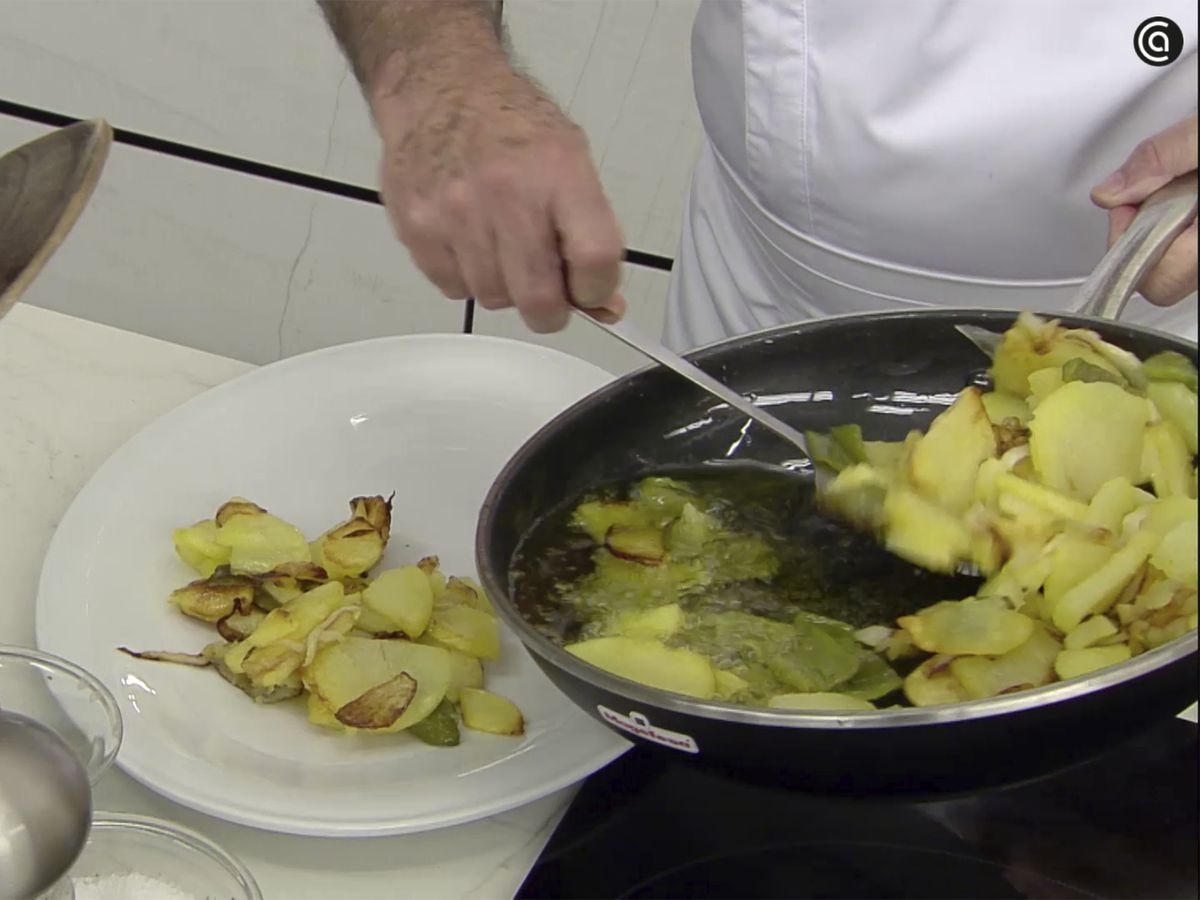 Fríe las patatas con la cebolleta y el pimiento verde