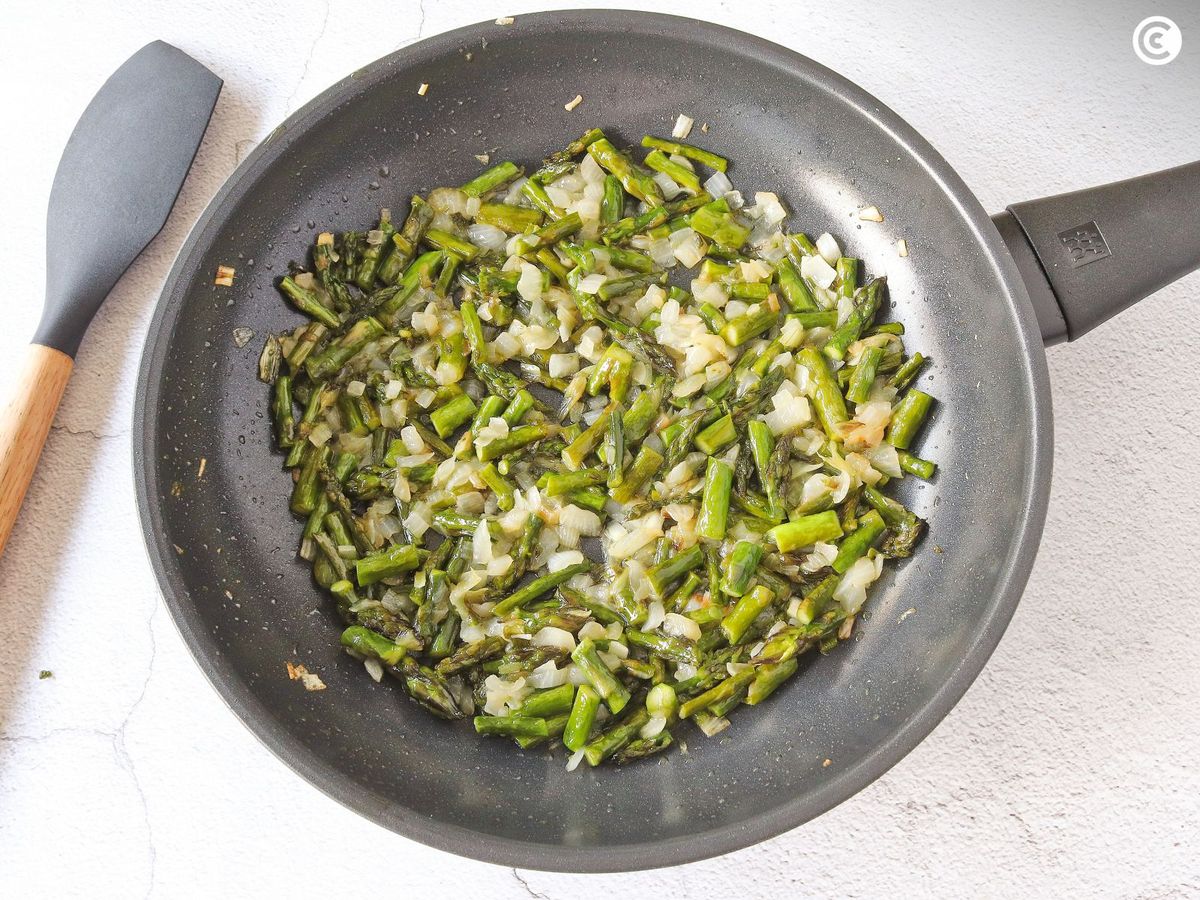 Pochar los espárragos y la cebolla para dar sabor a la tortilla