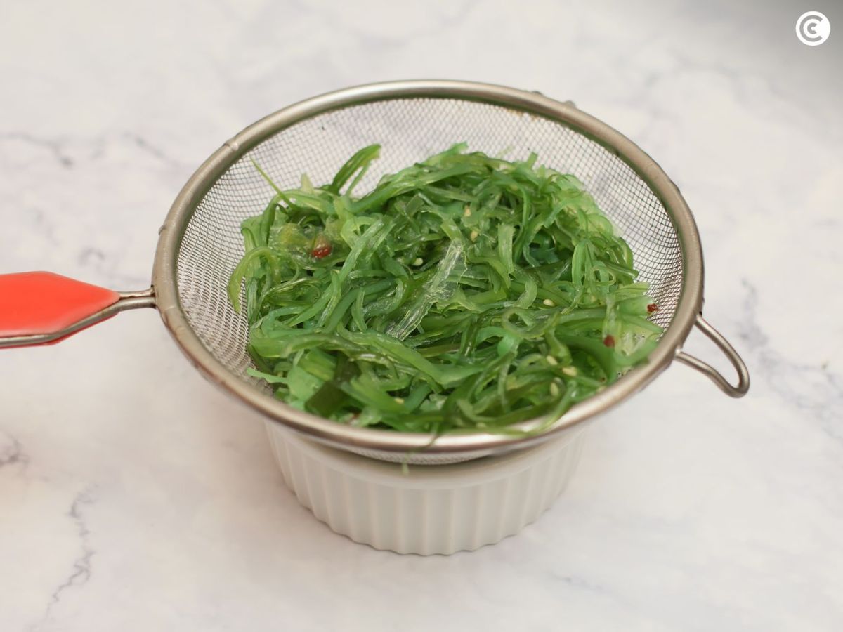 Escurrir las algas para la ensalada de wakame