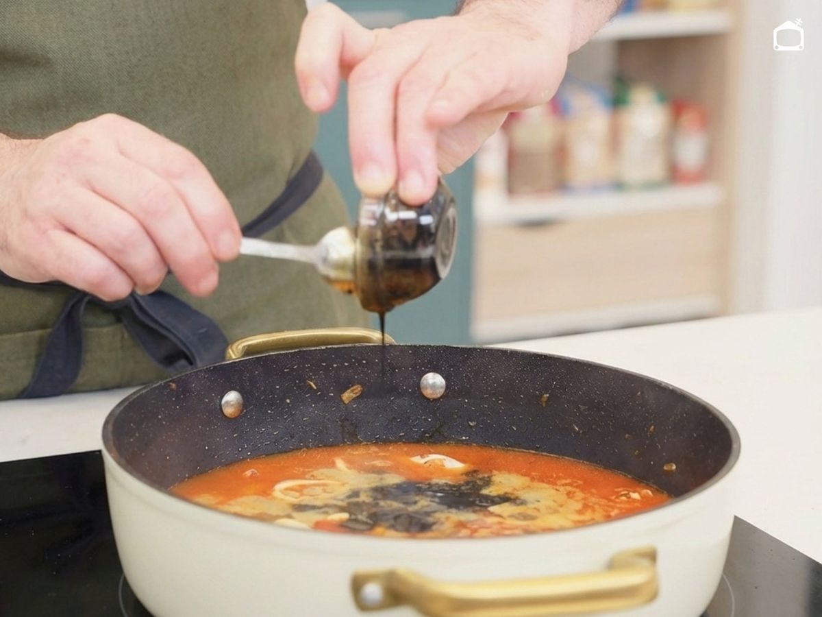 ncorpora el arroz al sofrito, cúbrelo con caldo, añade la tinta y deja cocinar