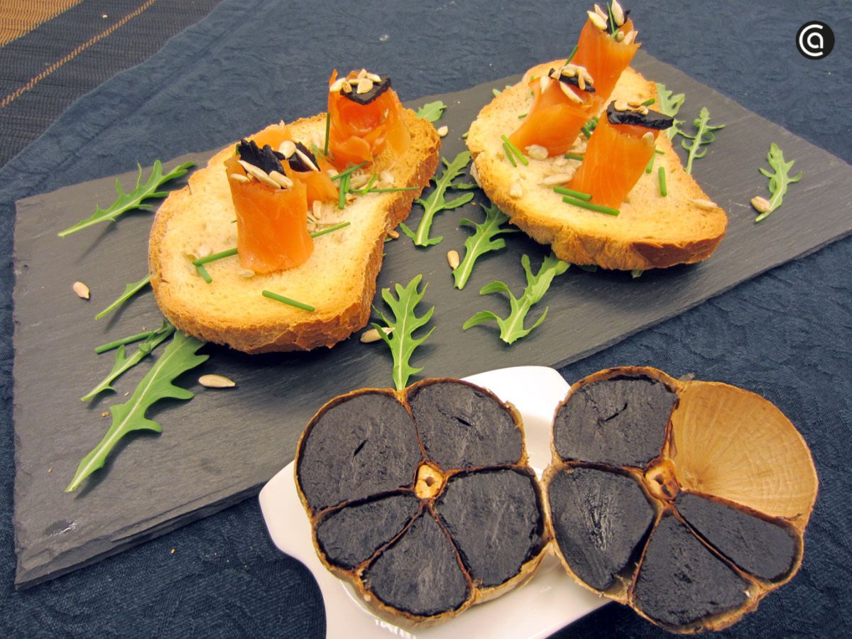 Tostas de salmón ahumado con ajo negro y pipas de girasol: aperitivo gourmet lleno de contrastes.