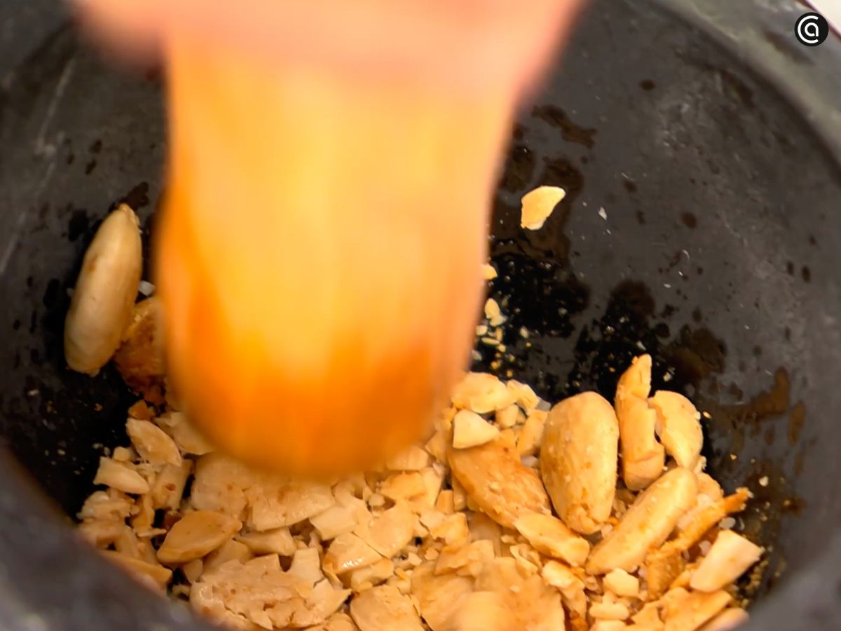 Tritura las almendras tostadas junto con los ajos en el mortero