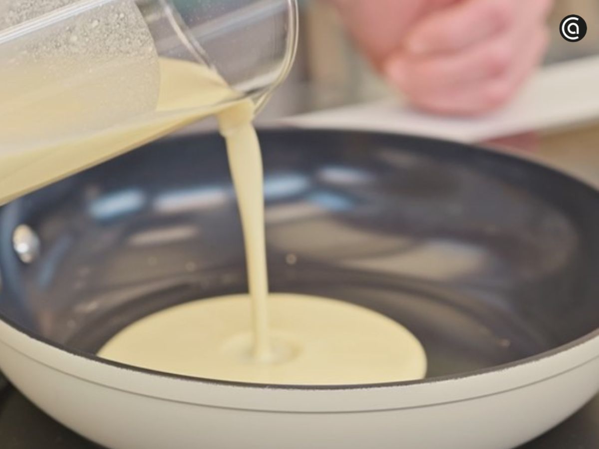 La masa se vierte en la sartén apenas engrasada para formar una capa fina.