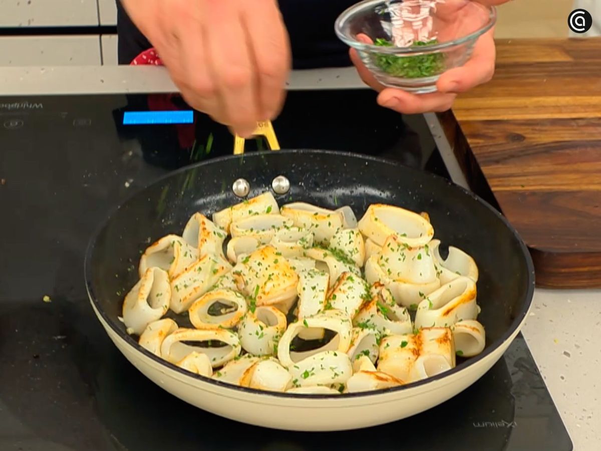 Saltea los chipirones con ajo, luego añade perejil picado