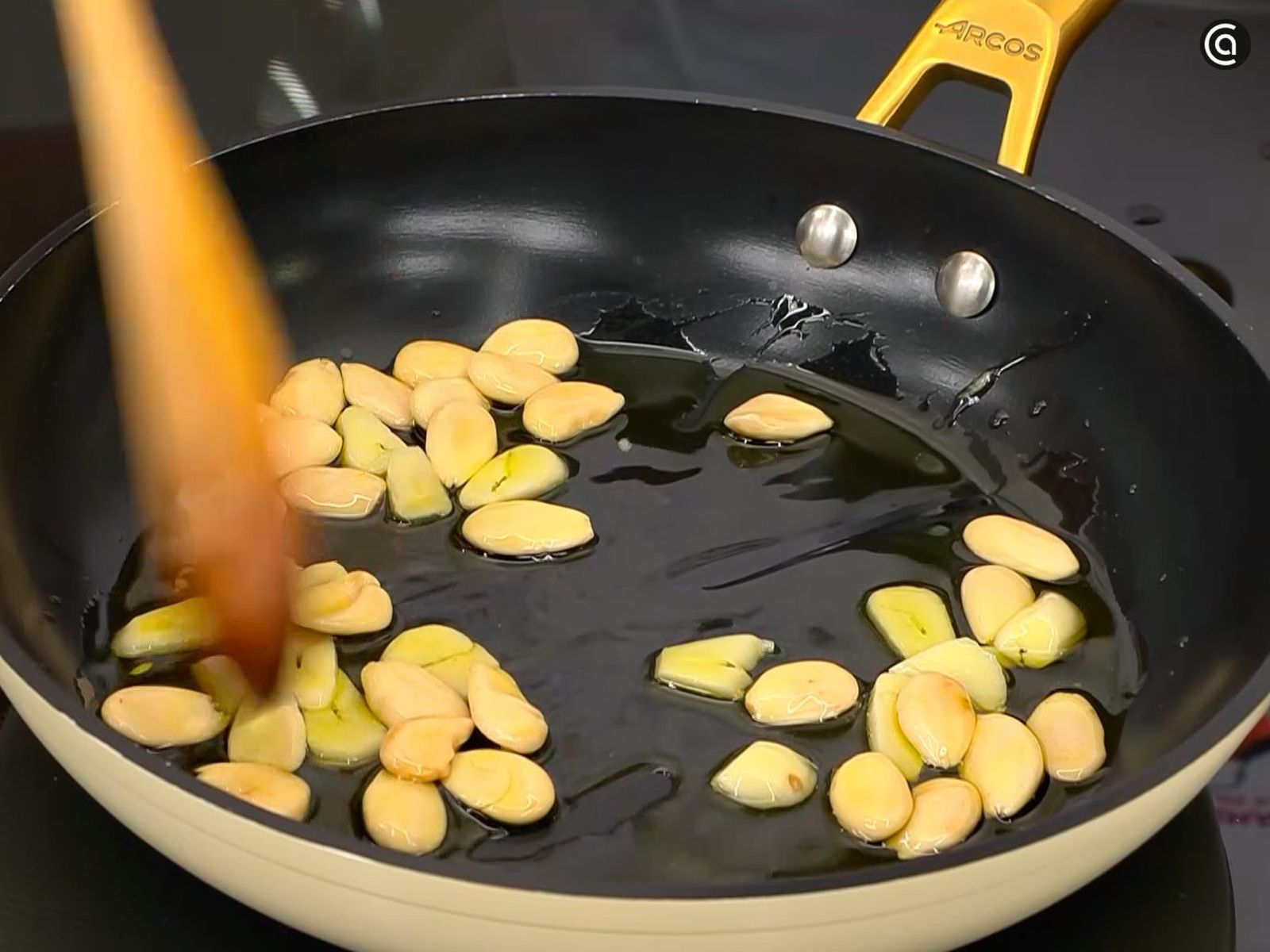 Dora las almendras y los ajos laminados en una sartén con aceite