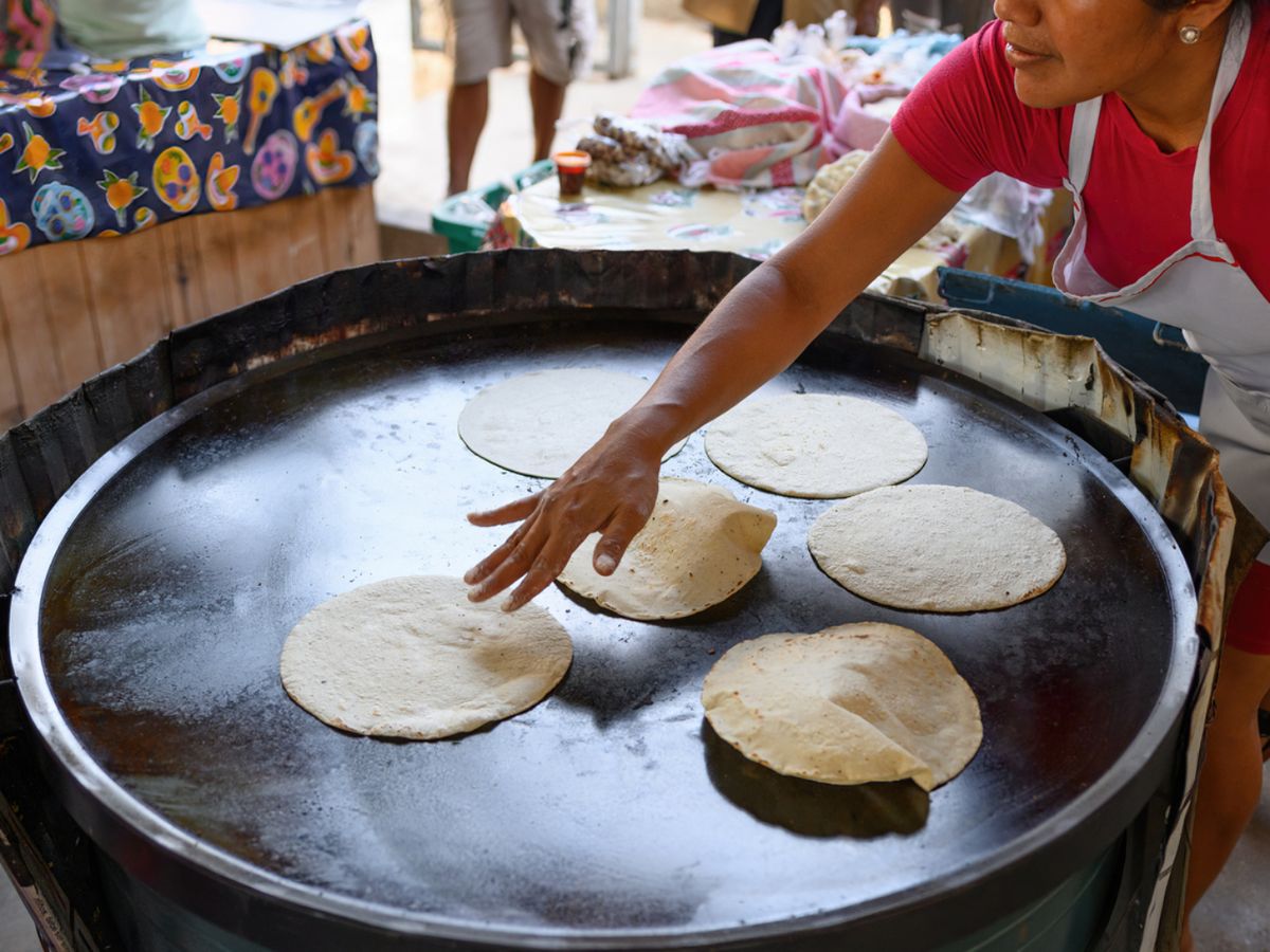 Tortillas de maíz calentándose en un comal tradicional, esenciales para preparar auténticas fajitas mexicanas.