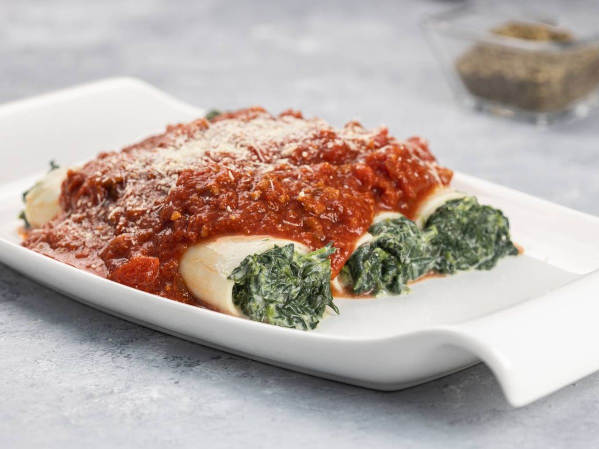Canelones de espinacas gratinados con salsa boloñesa, un plato clásico.