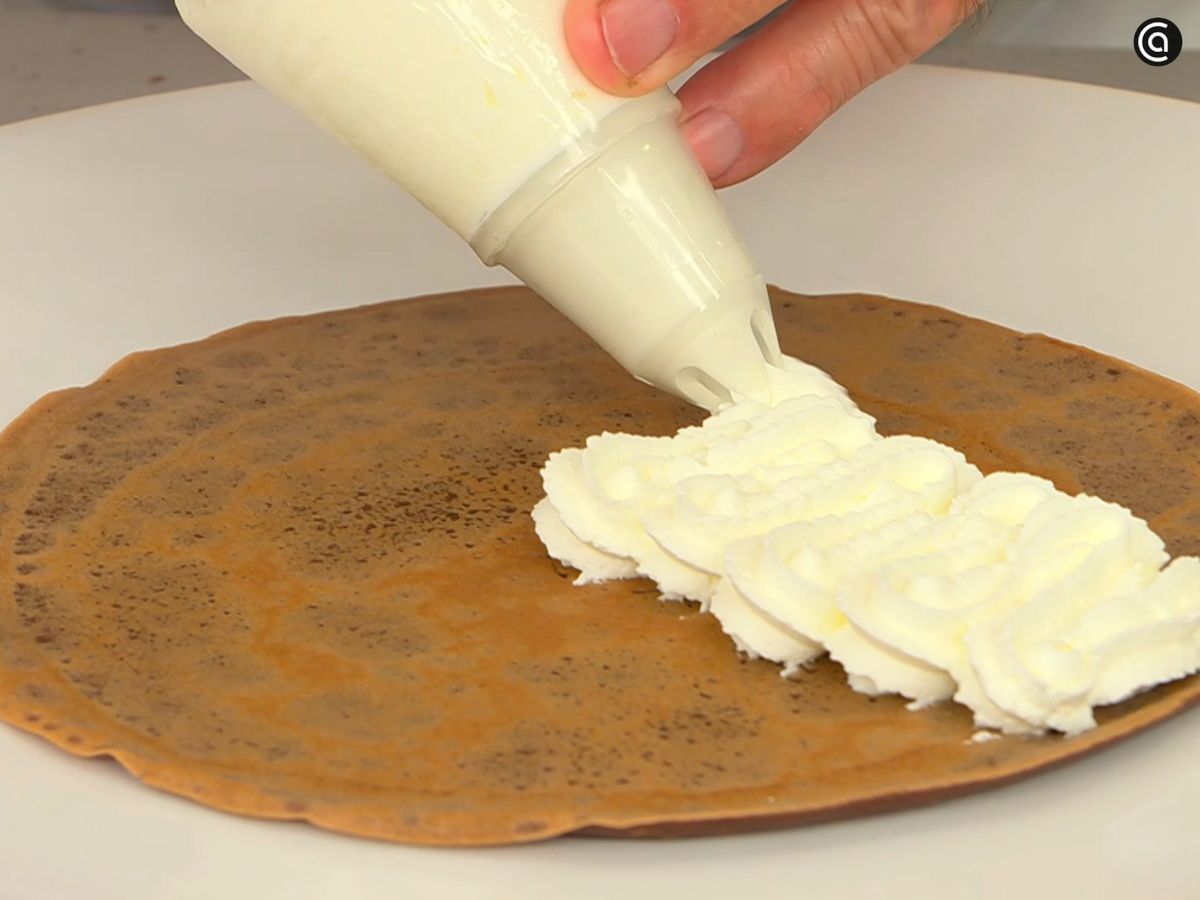 Monta la nata junto con azúcar glas y rellena los crepes