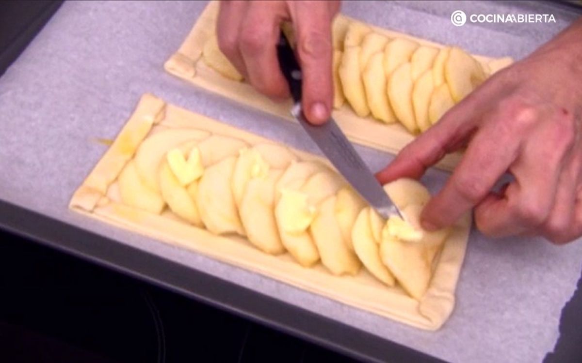 Coloca pequeñas porciones de mantequilla sobre las rodajas de manzanas