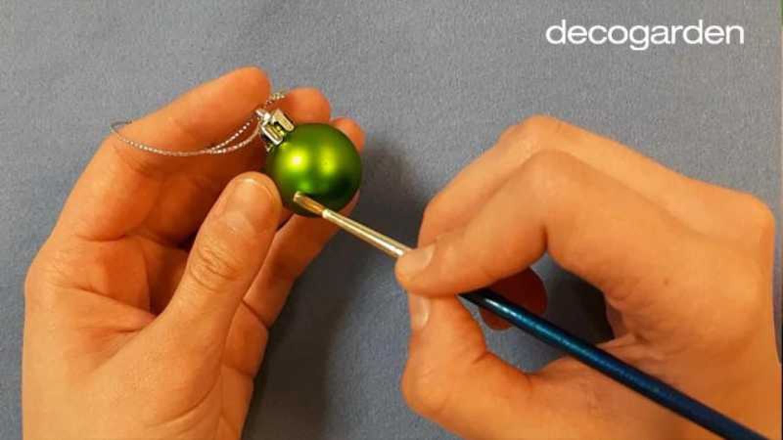 Pintar una bola de Navidad con bola blanca para hacer la huella de la mascota con brillantina. Pintar una bola de Navidad con bola blanca para hacer la huella de la mascota con brillantina.