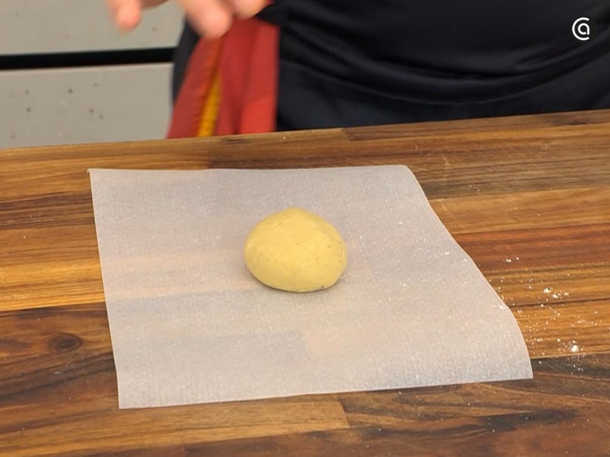 Con las manos enharinadas se forman pequeñas bolas de masa y se colocan sobre papel sulfurizado.