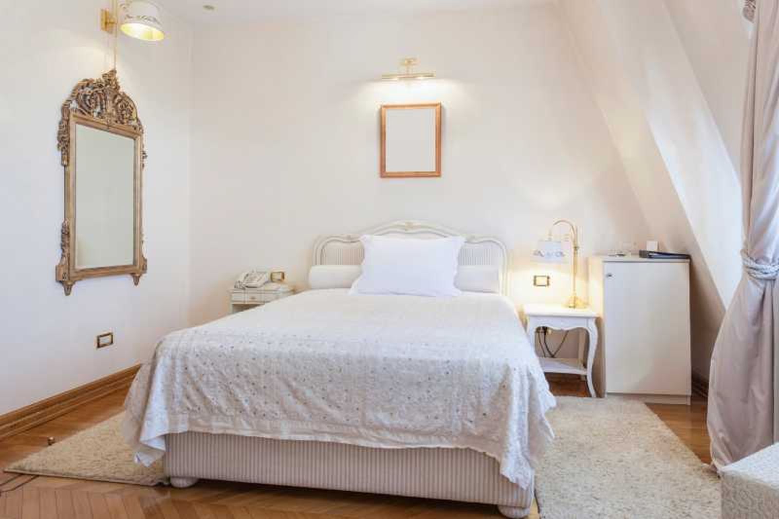 Dormitorio pequeño decorado con un espejo barroco. Dormitorio pequeño decorado con un espejo barroco.