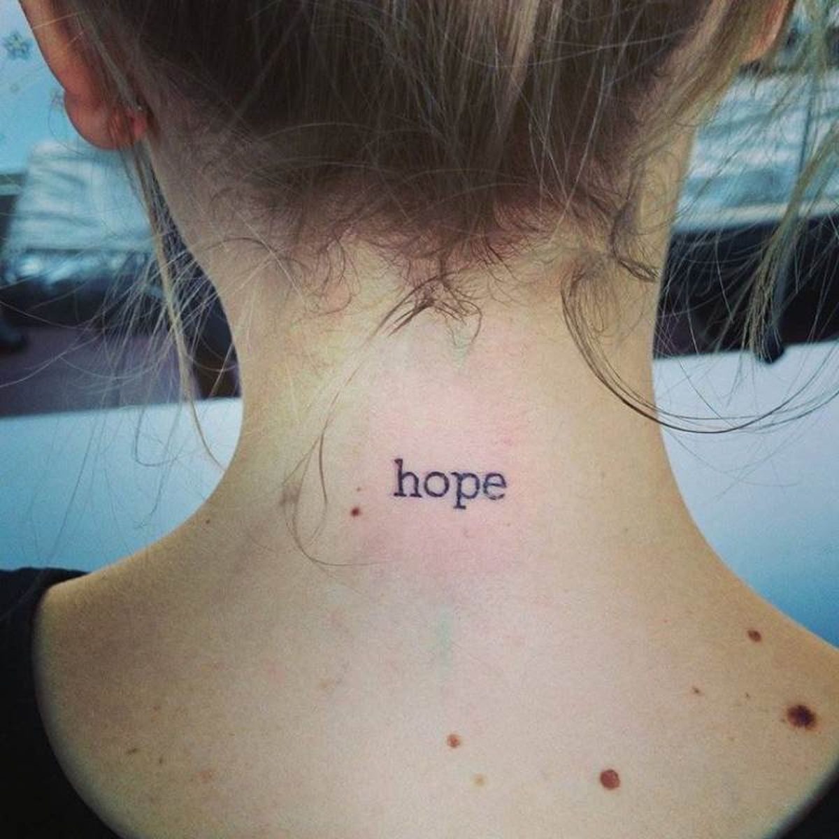 Pequeño tatuaje en al nuca