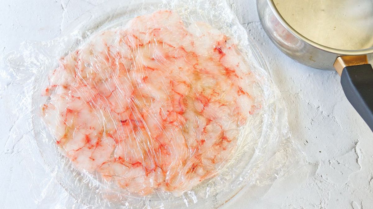 Gambas rojas cubiertas por papel film y aplastadas
