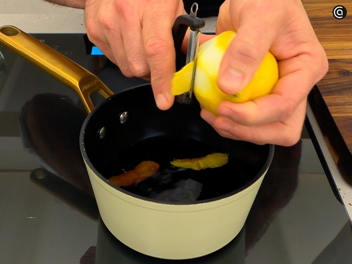 En un cazo, pon a reducir el refresco de cola con cáscaras de limón