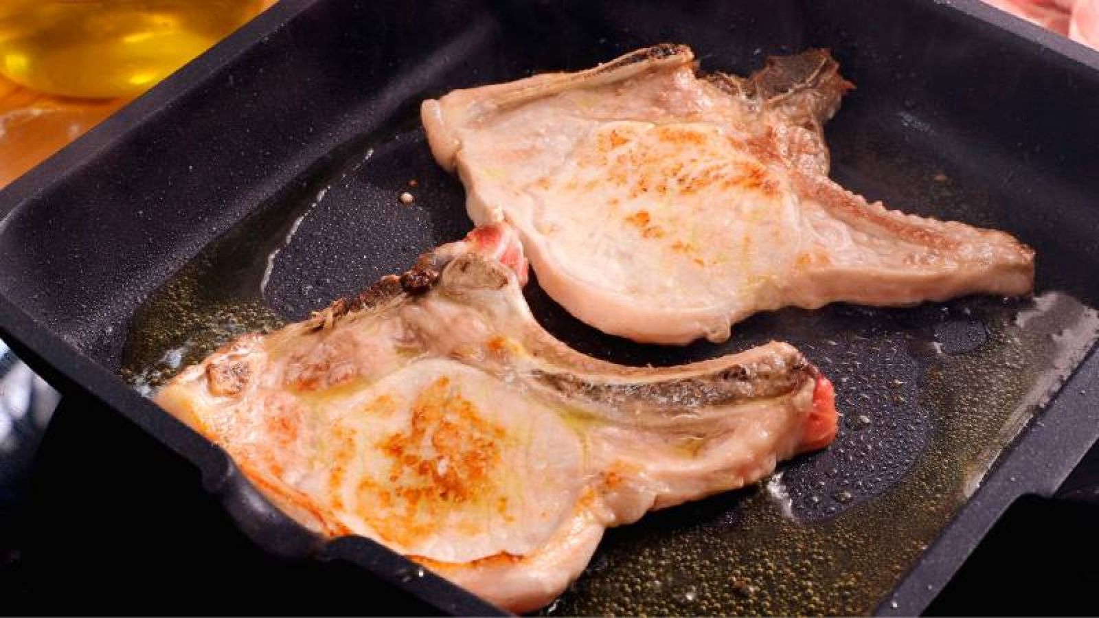 Dora las chuletas de cerdo en la plancha caliente para sellar sus jugos y obtener un dorado perfecto Dora las chuletas de cerdo en la plancha caliente para sellar sus jugos y obtener un dorado perfecto