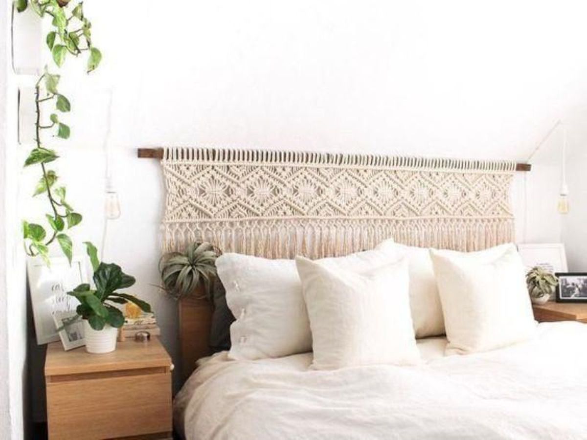 Cabecero con tela neutra y cojines en tonos suaves