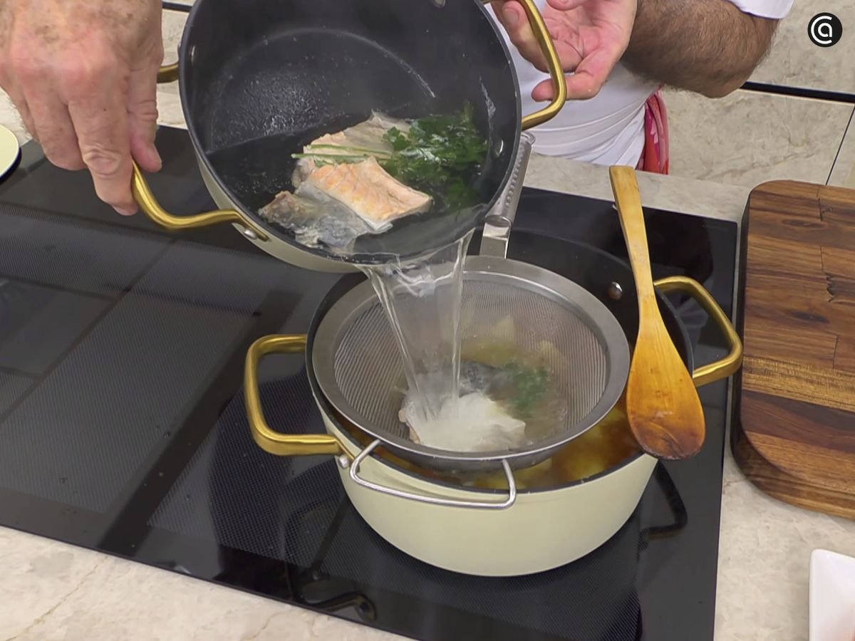 Añade el caldo de pescado pasándolo por un colador y cocina a fuego lento