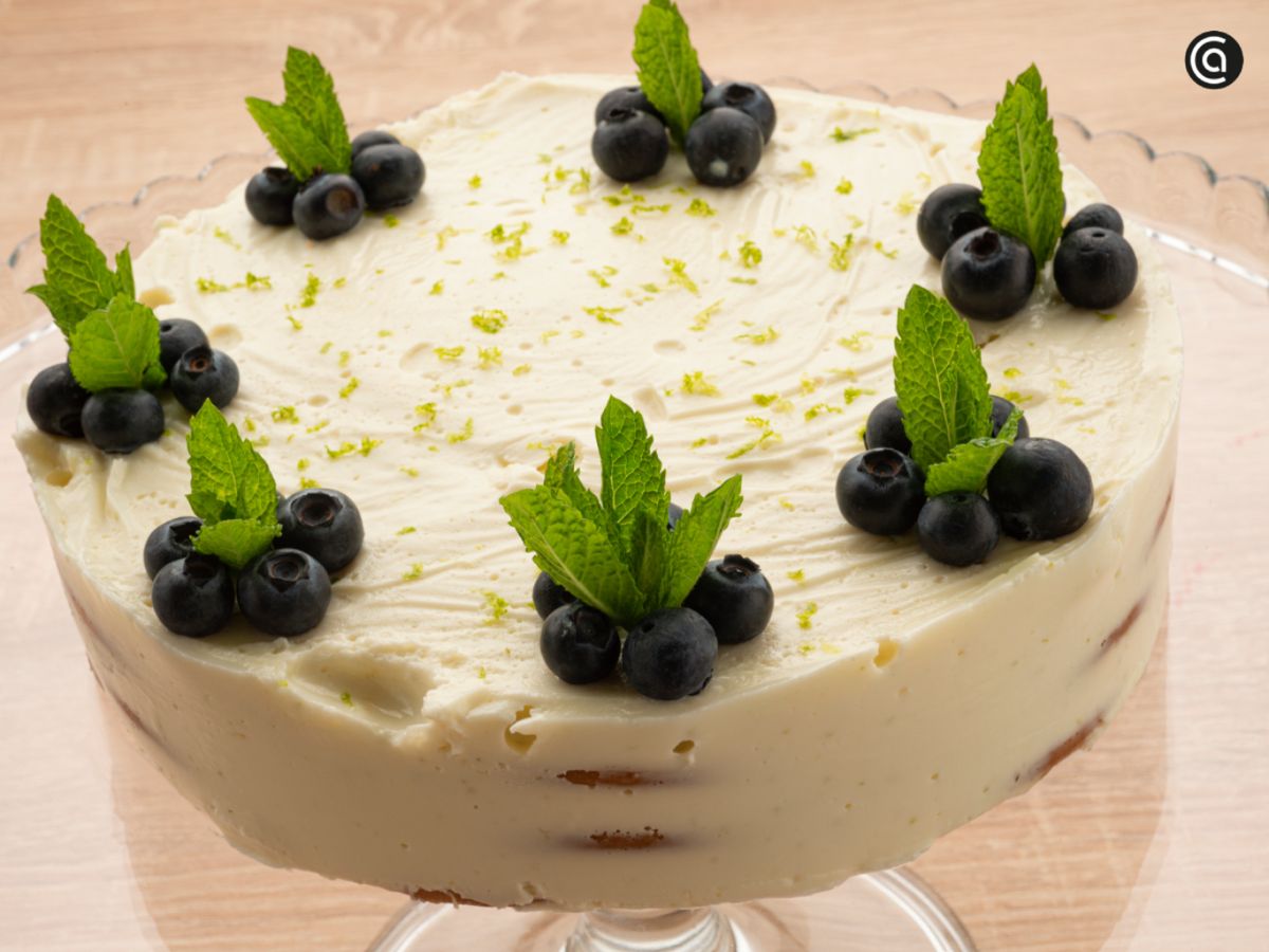 Carlota de limón decorada con arándanos y hojas de menta, un postre frío perfecto para el verano.