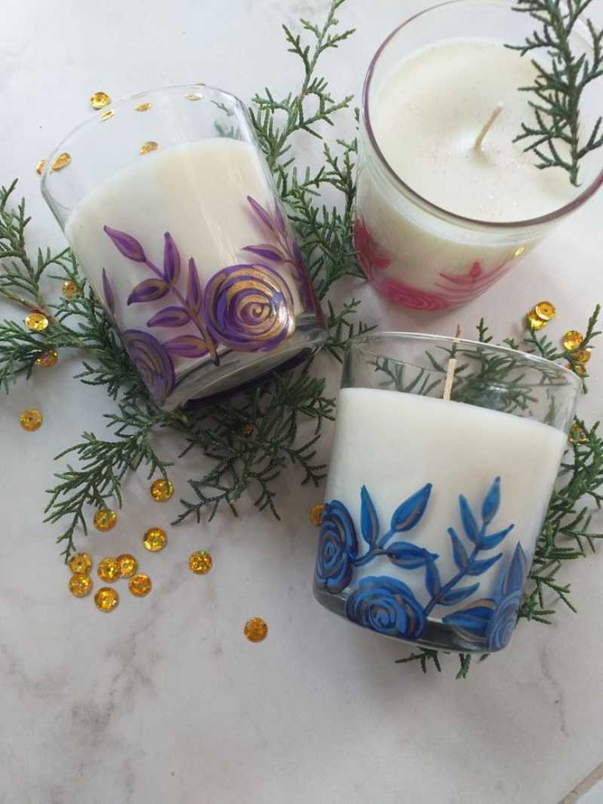 Portavelas de cristal pintados con flores de colores y pintura dorada.