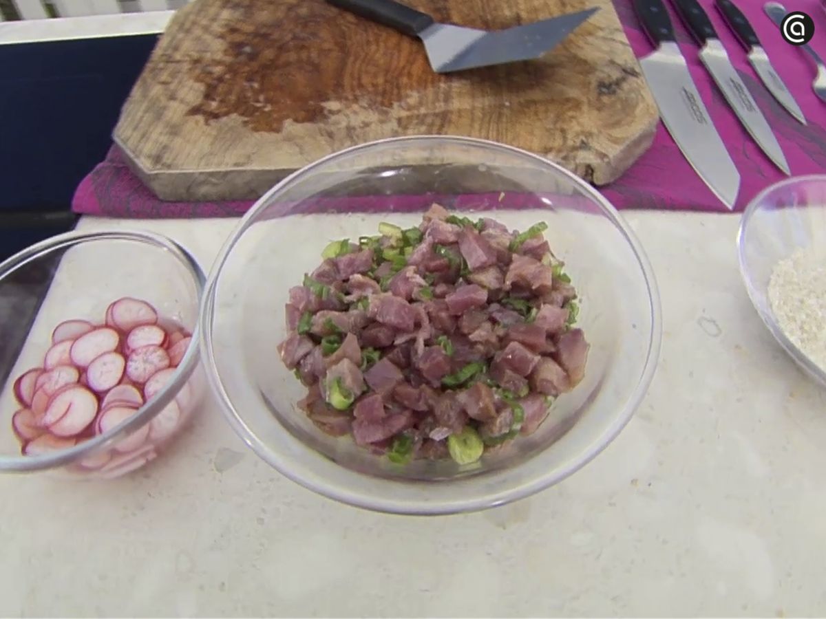 Marina el atún con la salsa de soja, el aceite de sésamo y los tallos de las cebolletas